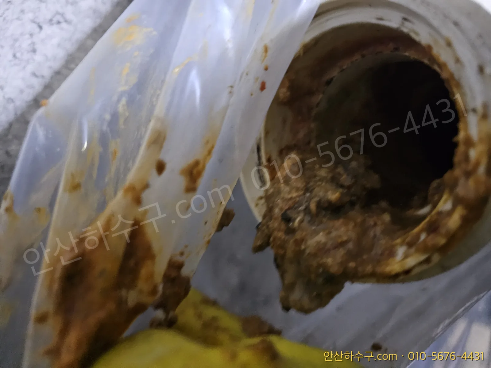 본오동 식당 주방 배관 안에 굳어 있는 기름때와 찌꺼기를 점검하는 모습