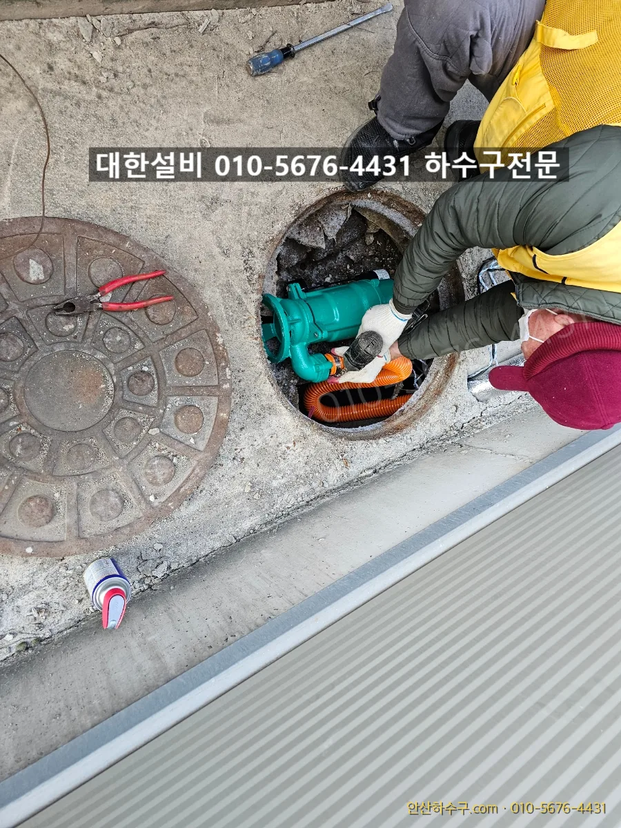좁은 맨홀 안으로 수중모터를 조심스럽게 내려 안착시키는 작업